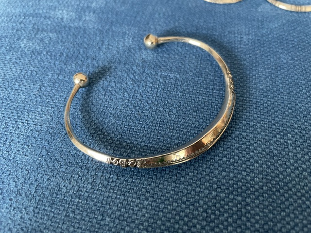 Bracelet jonc ouvert, forme évasée. Deux boules